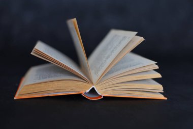 Siyah arkaplan üzerine açık bir kitap, karanlık bir arkaplan üzerine bir kitabın sayfaları, eğitim.
