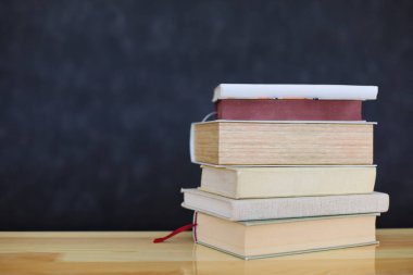 Tahta masadaki kitap yığını.