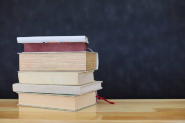 Duvarın önündeki masada yığınla kitap var. yüksek kaliteli fotoğraf