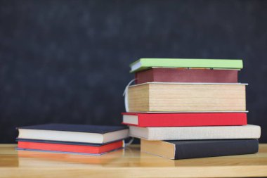 Tahta masadaki kitap yığını.