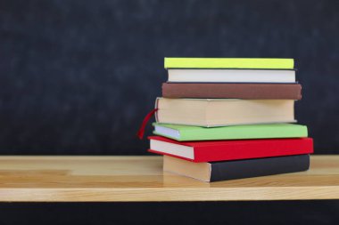 Bir yığın kitap ve renkli ahşap raf.