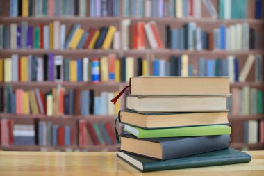 Kütüphanedeki masanın üzerinde kitap yığını, metin için boşluk