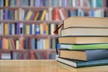 Kütüphanenin önündeki masaya yığınla kitap.