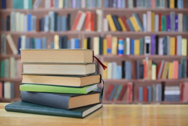 Kütüphanede ahşap arkaplan üzerine kitap yığını