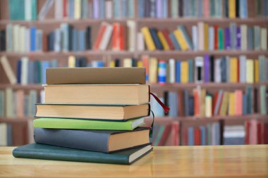 Ahşap arka plandaki tahta kutuda yığınla kitap.