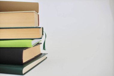 Kütüphanede beyaz tabloda kitap yığını