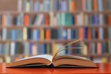 Kütüphanedeki ahşap masada yığınla kitap.