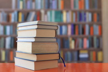 Kütüphanenin arka planına karşı kitap yığını