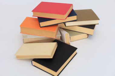 Beyaz arkaplandaki farklı kitapların yığını