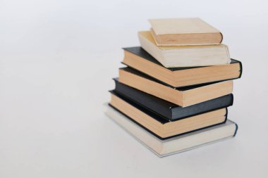 Beyaz masa, kitap yığını, kitap, yapay zeka, beyaz zemin üzerine kitaplar, beyaz zemin üzerine ünlü yazarların güzel kitapları, öğrenme, bilgi, okuma, öğrenim, İngilizce dili, İspanyolca dil, Çince
