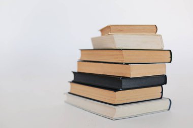 Beyaz masa, kitap yığını, kitap, yapay zeka, beyaz zemin üzerine kitaplar, beyaz zemin üzerine ünlü yazarların güzel kitapları, öğrenme, bilgi, okuma, öğrenim, İngilizce dili, İspanyolca dil, Çince