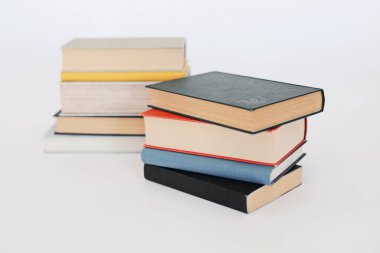 Beyaz masa, kitap yığını, kitap, yapay zeka, beyaz zemin üzerine kitaplar, beyaz zemin üzerine ünlü yazarların güzel kitapları, öğrenme, bilgi, okuma, öğrenim, İngilizce dili, İspanyolca dil, Çince