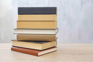 Ahşap arka planda bir yığın kitap, kütüphanenin arka planına karşı bir yığın kitap, kütüphanenin önünde bir yığın kitap, ahşap masa üzerine kitaplar.