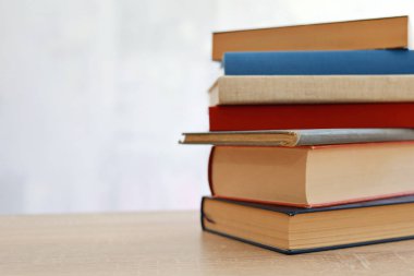 Bulanık arka plan, okuma, öğrenme, öğrenme, bilgi ve edebiyata karşı ahşap masadaki kitap yığını