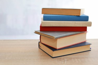 Bulanık arka plan, okuma, öğrenme, öğrenme, bilgi ve edebiyata karşı ahşap masadaki kitap yığını