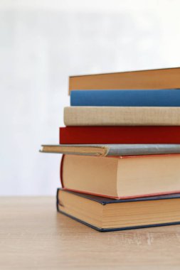 Bulanık arka plan, okuma, öğrenme, öğrenme, bilgi ve edebiyata karşı ahşap masadaki kitap yığını