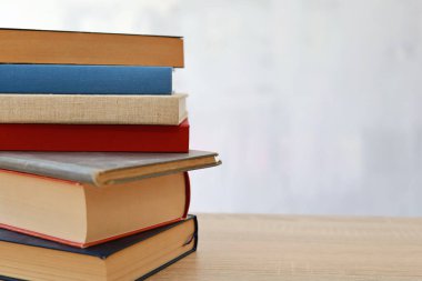 Bulanık arka plan, okuma, öğrenme, öğrenme, bilgi ve edebiyata karşı ahşap masadaki kitap yığını