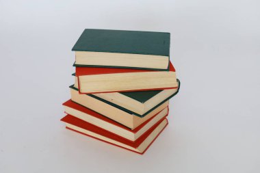 Tahta masadaki kitap yığını, beyaz arka planda izole.