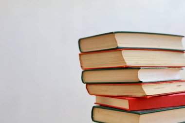 Beyaz arkaplanda izole edilmiş renkli kitapların yığını.