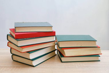 stack of books on table against color wall