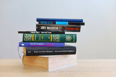 Makarska, Hırvatistan, 27.07.2024. Ünlü yazarların kitapları: Jure Divich, Mihail Bulgakov, Patrik Modiano, Cody McFadyen, William Shakespeare, Fyodor Mihajlovic Dostoyevski, Ernest Hemingway, W. Faulkner, ahşap bir masa üzerindeki kitaplar, ai