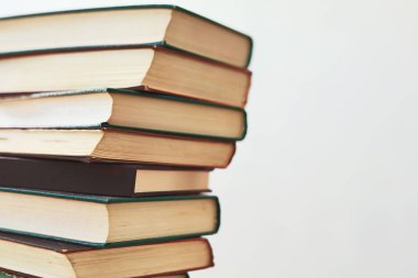 beyaz ahşap masa üzerinde kitap yığını.