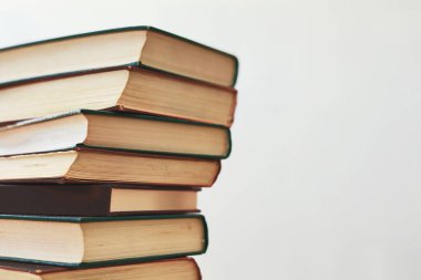 Kopyalama alanı olan hafif bir arkaplan üzerindeki eski kitap yığını.