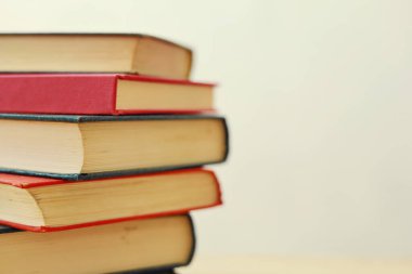 Beyaz arkaplana karşı ahşap masadaki kitap yığını