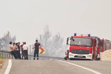 Tucepi, Hırvatistan, 31,07.2024. Büyük bir orman yangınında, Hırvatistan kıyısındaki evlerin yakınında, deniz kıyısındaki bir turizm beldesinde, yol kenarında bir yangın ile birlikte bir orman yandı.