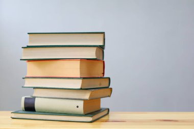 Ahşap masanın üzerinde bulanık arka plana karşı bir yığın kitap. metin için alan, masada kırmızı kitaplar, eğitim, okuma, öğrenme, bilgi, edebiyat, eğitim geçmişi, romantizm romanı, şiir koleksiyonu, yüksek kaliteli kitap fotoğrafları