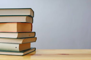 Ahşap masanın üzerinde bulanık arka plana karşı bir yığın kitap. metin için alan, masada kırmızı kitaplar, eğitim, okuma, öğrenme, bilgi, edebiyat, eğitim geçmişi, romantizm romanı, şiir koleksiyonu, yüksek kaliteli kitap fotoğrafları