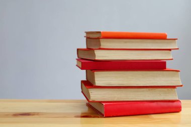 Ahşap masanın üzerinde bulanık arka plana karşı bir yığın kitap. metin için alan, masada kırmızı kitaplar, eğitim, okuma, öğrenme, bilgi, edebiyat, eğitim geçmişi, romantizm romanı, şiir koleksiyonu, yüksek kaliteli kitap fotoğrafları