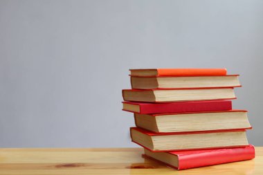 Ahşap masanın üzerinde bulanık arka plana karşı bir yığın kitap. metin için alan, masada kırmızı kitaplar, eğitim, okuma, öğrenme, bilgi, edebiyat, eğitim geçmişi, romantizm romanı, şiir koleksiyonu, yüksek kaliteli kitap fotoğrafları