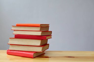 Ahşap masanın üzerinde bulanık arka plana karşı bir yığın kitap. metin için alan, masada kırmızı kitaplar, eğitim, okuma, öğrenme, bilgi, edebiyat, eğitim geçmişi, romantizm romanı, şiir koleksiyonu, yüksek kaliteli kitap fotoğrafları