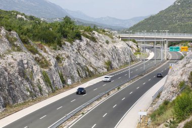 Bir dağ yolu ve arkasında dağlar olan bir otoyol.