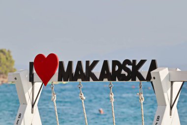 Deniz kıyısındaki Makarska 'nın işareti, Hırvatistan' ın güneyindeki bir turizm beldesinin markası, pek çok Alman, Çek, Polonyalı, Slovak ve İtalyan 'ın yazlık tatil beldesi, kırmızı kalpli ahşap mektuplar, aşk, romantizm, sevgililer günü, düğün. ai