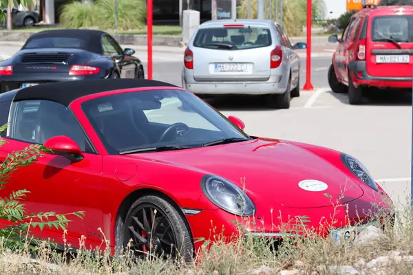 kırmızı lüks araba sokağa park edilmiş.