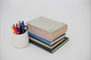 Bir yığın kitap ve bir kalem.
