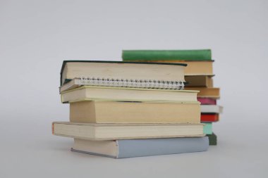 çok renkli kitaplar ve yığınla kitap, kütüphanenin arka planına karşı kitap yığını, kütüphanenin önünde yığınla kitap, ahşap masa, eğitim, yüksek kaliteli kitap fotoğrafçılığı, en iyi kitap fotoğrafı, yapay zeka,