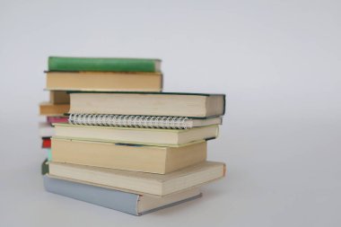 çok renkli kitaplar ve yığınla kitap, kütüphanenin arka planına karşı kitap yığını, kütüphanenin önünde yığınla kitap, ahşap masa, eğitim, yüksek kaliteli kitap fotoğrafçılığı, en iyi kitap fotoğrafı, yapay zeka,