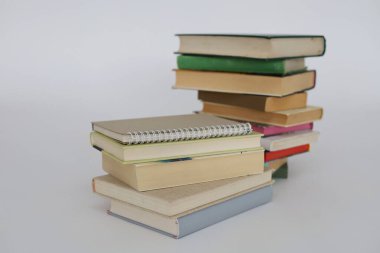 çok renkli kitaplar ve yığınla kitap, kütüphanenin arka planına karşı kitap yığını, kütüphanenin önünde yığınla kitap, ahşap masa, eğitim, yüksek kaliteli kitap fotoğrafçılığı, en iyi kitap fotoğrafı, yapay zeka,