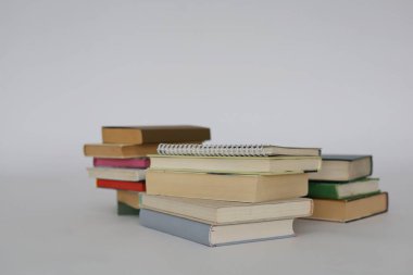 çok renkli kitaplar ve yığınla kitap, kütüphanenin arka planına karşı kitap yığını, kütüphanenin önünde yığınla kitap, ahşap masa, eğitim, yüksek kaliteli kitap fotoğrafçılığı, en iyi kitap fotoğrafı, yapay zeka,