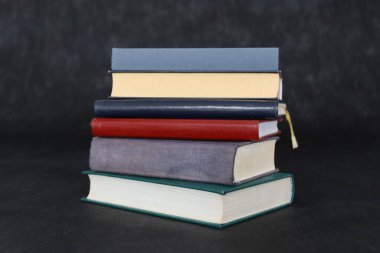 Siyah arkaplanla ilgili bir sürü kitabı olan bir yığın kitap. Boşluğu kopyala.