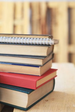 Tahta masadaki kitap yığını.