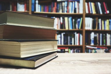 Tahta masadaki kitap yığını.