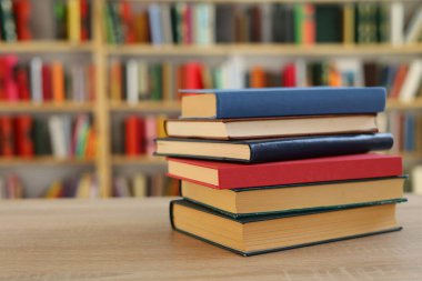 Kütüphanedeki masanın üzerinde kitap yığını