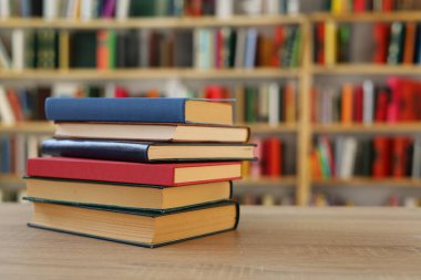 Kütüphanedeki masanın üzerinde kitap yığını