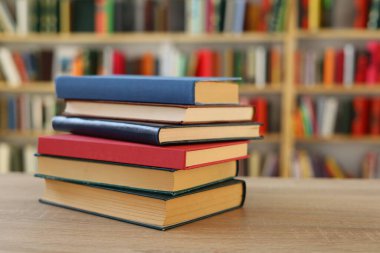 Kütüphanedeki masanın üzerinde kitap yığını