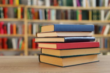 Kütüphanedeki masanın üzerinde kitap yığını