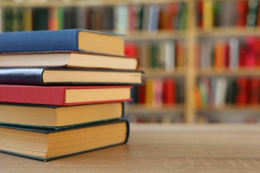 Kütüphanedeki masanın üzerinde kitap yığını